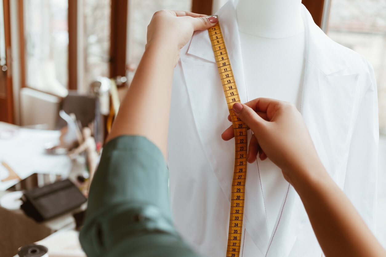 Tailor taking measurements illustrating personalized DevOps and software design